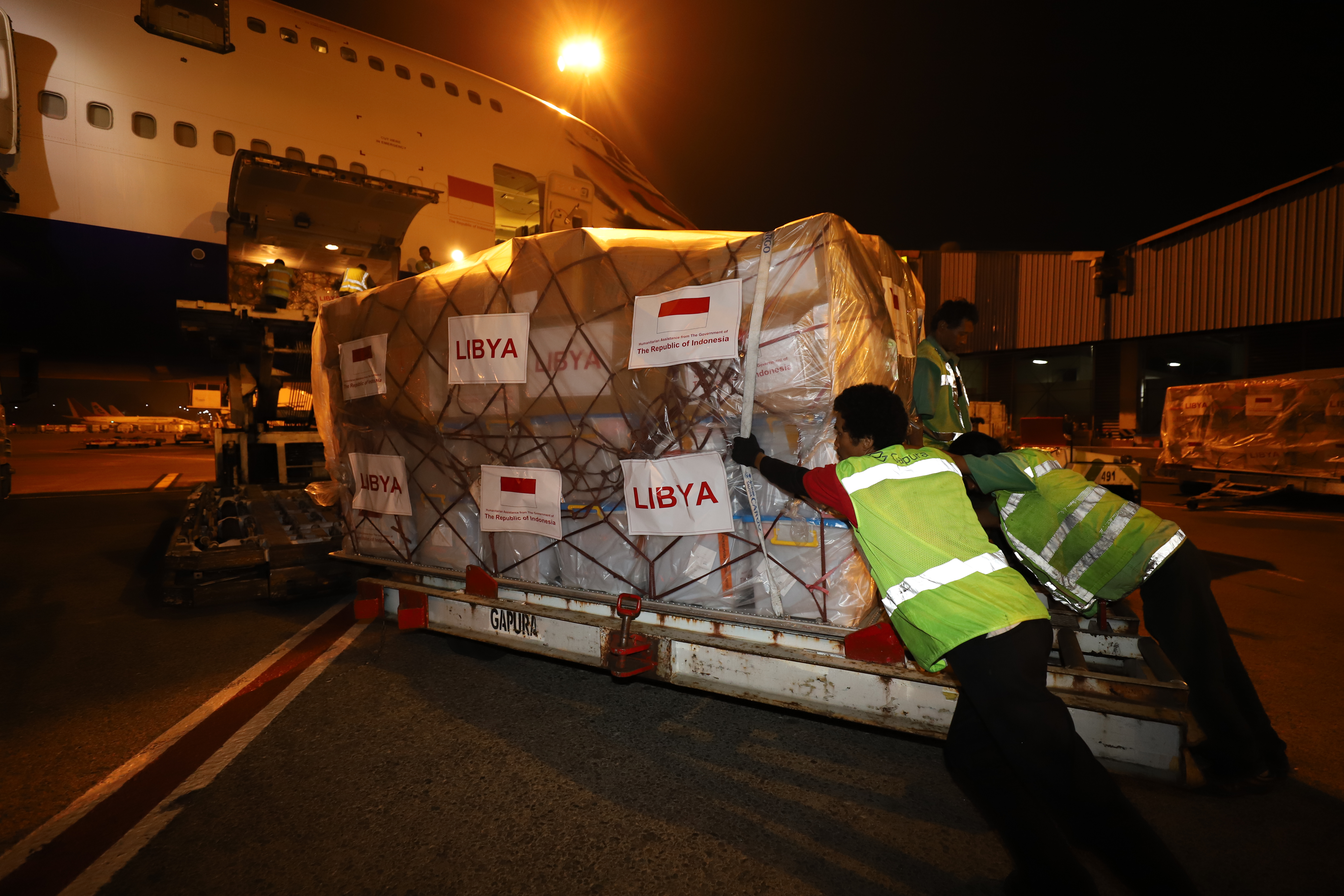 Para petugas sedang memasukan barang bantuan dukungan logistik dari Pemerintah Indonesia ke dalam pesawat yang akan membawa ke Libya dari Bandara Soekarno Hatta, Kota Tangerang, Banten, Selasa (2/10) dini hari.